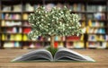 Tree growing from book A big open book with tree Reading makes y