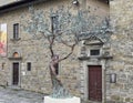 \'Tree of Life\' bronze sculpture by Andrea Roggi with Diocesan Museum in the background in Cortona, Italy.