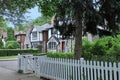 Tree lined residential street with older two story Tudor style houses