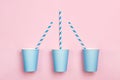 Tree mint blue paper drinking cup and striped straws on pink background. Birthday party celebration abstract fashion Royalty Free Stock Photo