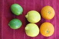 Tree pair of citrus fruits on red cloth, lined up by size Royalty Free Stock Photo