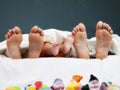 Tree pairs of legs of the happy family in bed Royalty Free Stock Photo