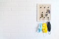 Tree protective face masks on the keys organizer hook on the loft design white background brick wall in the home hallway. Health