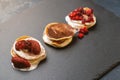 Tree stacks of mini pancakes with strawberry and chocolate on bl Royalty Free Stock Photo