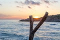 A tree stump on the beach and behind it an island at sunset, the Mediterranean Sea Jijel Algeria, Africa island. Royalty Free Stock Photo