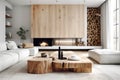 Tree stump coffee table near white sofa and pouf against wood paneling wall with fireplace and stack of firewood. Scandinavian