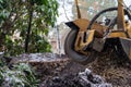 Tree stump removing process with yellow stump grinder Royalty Free Stock Photo