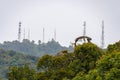Tree tops of tropical rain forest in front of modern transmission towers