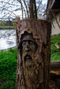 Tree trunk with face of old looking person carved into the wood in Cambridge, England Royalty Free Stock Photo