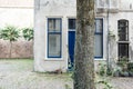 Tree trunk in front of old white colored house in dutch city Deventer. Overijssel, Netherlands. Royalty Free Stock Photo