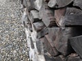 Tree trunks stacked and gravel background - shades of grey