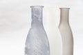 tree vases for flowers of gray shades on a white background