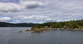 Treed Island with Homes, boats and docks, nearby smaller island with lighthouse Royalty Free Stock Photo