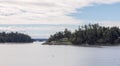 Treed Island with Homes, boats and small dock, surrounded by smaller islands. Royalty Free Stock Photo