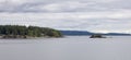 Treed Island with Houses and Docks, near small island with lighthouse. Royalty Free Stock Photo