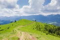 Treeless mountain crest with dirt road against distant mountain ridges