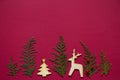 Treeline shape made of thuja branches and wooden figures of Christmas tree and deer. Minimal winter creative table flat lay Royalty Free Stock Photo