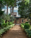 A treelined path leads to a Mamluk style building surrounded by lush greenery