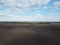 Trees along an irrigation canal on a plowed field top view. Farmland