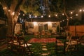 Trees in backyard are lit up with string lights, creating a cozy and intimate ambiance, A cozy backyard ceremony with intimate Royalty Free Stock Photo