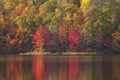 Trees in brilliant autumn color reflecting in a small lake in northern Minnesota