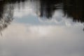 Trees and clouds reflecting in river, abstract photo with copy space Royalty Free Stock Photo