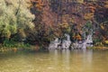 trees in fall foliage on the rocky shore of a river