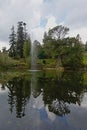 Trees and fountain reflectin in the water in Powerscourt gardens