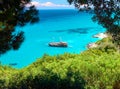 Trees frame beautiful view on amazing island bay with pirate corsair style boat ship, swimming people, beach in Ionian Sea blue wa Royalty Free Stock Photo