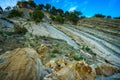 Trees grow on the rock. In background blue sky with clouds. Royalty Free Stock Photo