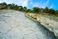 Trees grow on the rock. In background blue sky with clouds. Royalty Free Stock Photo