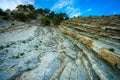 Trees grow on the rock. In background blue sky with clouds. Royalty Free Stock Photo