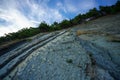 Trees grow on the rock. In background blue sky with clouds. Royalty Free Stock Photo