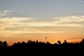 Trees and Mobile phone antenna tower silhouette in sunset Royalty Free Stock Photo