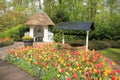 A water well and pavilon and blooming tulips in the flower garden Keukenhof in spring.