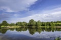Trees reflected to lake water at countryside in Europe against summer dramatic sky Royalty Free Stock Photo