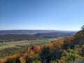 Trees turning colors in fall from top of mountain sunny day Royalty Free Stock Photo