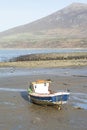 Small lone fishing boat on sand flats at low tide at Trefor, north Wales.