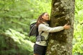 Trekker embracing a tree in a forest