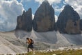 Trekker in front of the Drei Zinnen in a cloudy day of summer, D