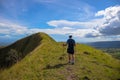 Trekker goes on the top of hill in the mountains. Tourist travels through the mountains. Outdoor activities. Mountain landscape