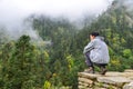 A trekker looking at the misty forest