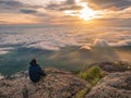 Trekker sitting on the mountain with Beautiful Sunrise and sea of mist in the morning on Khao Luang mountain Royalty Free Stock Photo