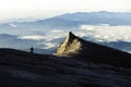 Trekker standing on Kinabalu mountain with south peak and mountain range in background