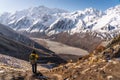 A trekker standing on top of Kyanjin Ri view point and taking picture of Langtang mountain range, Himalaya mountains range in