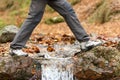 Trekker walking crossing a river in winter Royalty Free Stock Photo