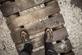 A trekker walking long a small wooden bridge