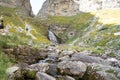 trekker woman and her dog approaching a river waterfall in Ordesa National Park, in the Spanish Pyrenees