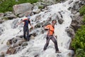 Trekkers are crossing mountanious river Royalty Free Stock Photo