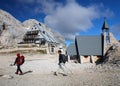 Trekkers near Kredarica mountain hut and the chapel dedicated to Our Lady of the Snows in Slovenia. Royalty Free Stock Photo